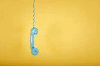 telefono-vintage-blu-che-appende-sullo-spazio-giallo.jpeg