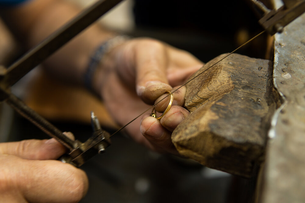 gioielliere-che-lavora-nel-suo-laboratorio-tagliando-un-anello-d-oro-con-una-sega.jpeg gioielliere-che-lavora-nel-suo-laboratorio-tagliando-un-anello-d-oro-con-una-sega.jpeg