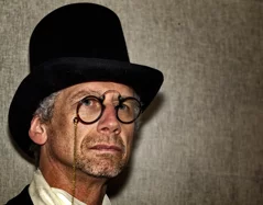  an elderly gentleman wearing a top hat, a man dressed in 19th-century clothing