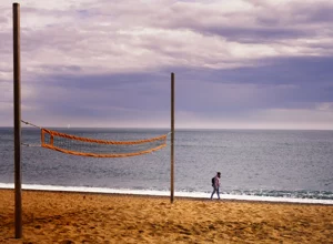 foto di spiaggia e rete, persona solitaria sulla spiaggia, 