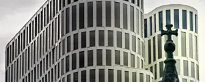 A white hotel in the centre of Berlin, Photo of a white hotel with a wavy design and a cross in front of it, A white hotel in the centre of Berlin, Photo of a white hotel with a wavy design and a cross in front of it,