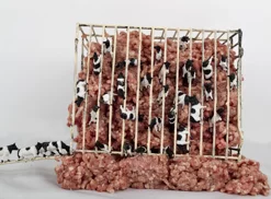 a cage containing cows and meat 