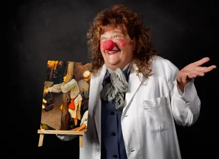 dressed as a hospital clown, she smiles in the portrait;