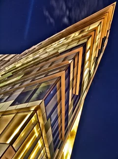 a building in modern Milan, photographed at night from below