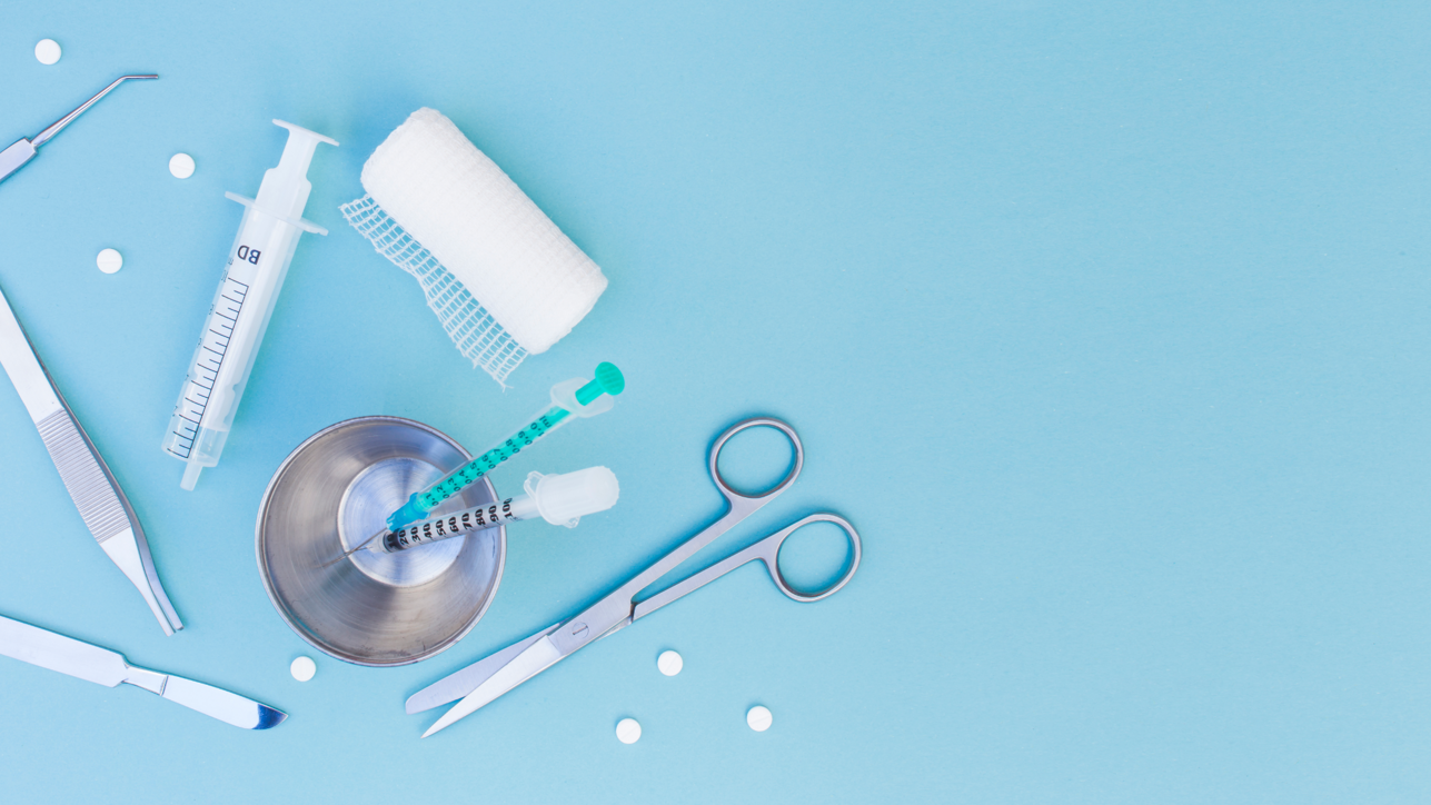 surgical-equipment-s-syringe-glass-pills-gauze-roll-blue-background