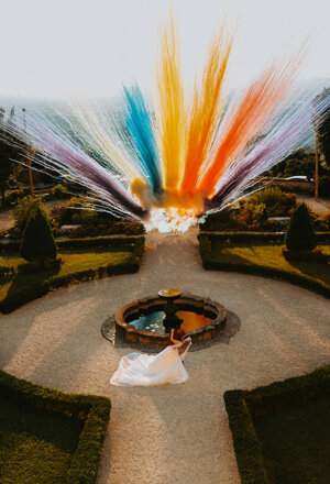 Esplosione di colori sopra una fontana nel giardino del ricevimento di matrimonio