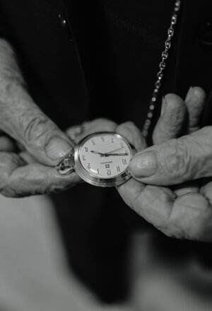 Mani che reggono un orologio da tasca durante i preparativi del matrimonio, in bianco e nero