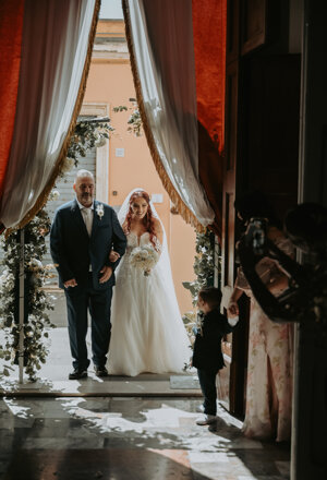 Ingresso della sposa con bouquet al braccio di un accompagnatore per la cerimonia di matrimonio