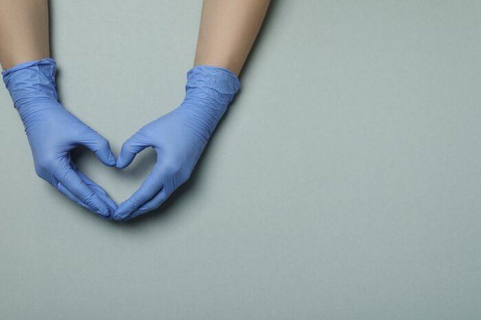 hands-medical-gloves-shows-heart-light-gray_185193-35952.jpeg