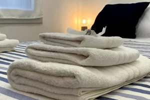 Letto matrimoniale con biancheria e asciugamani nella stanza Mirto a Cagliari