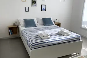 Letto matrimoniale nella Camera Ginepro di Cagliari Park Rooms