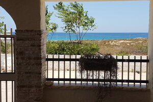 Vista mare da patio coperto con colonna in pietra e fioriera, Villetta Marisella a Pachino
