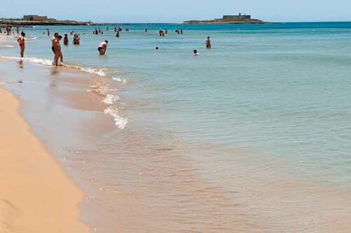 Mare turchese a Portopalo con bagnanti e sabbia dorata