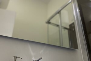 Bagno moderno con lavandino, specchio e box doccia in appartamento premium a Cagliari