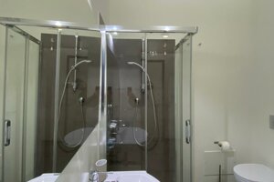 Bagno moderno con box doccia e lavabo in appartamento premium a Cagliari