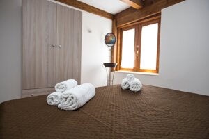 Camera da letto con travi in legno e asciugamani piegati all'Attico Perla Marina in contrada Morghella a Pachino