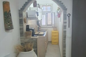 Cucina compatta con arco decorativo, mobili chiari e luce naturale, Villetta Marisella a Pachino