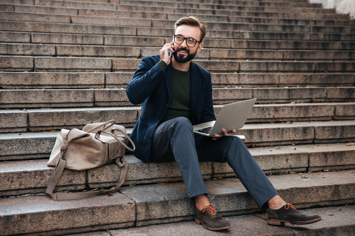 portrait-happy-man-eyeglasses-working-laptop