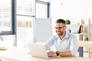 joyous-office-man-30s-white-shirt-sitting-desk-working-laptop-business-centre