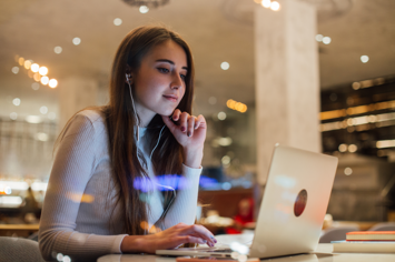 young-woman-works-laptop-earphones-office