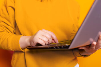 close-up-of-hand-of-person-using-modern-laptop-and-working-on-internet-connection-young-adult-holding-digital-computer-with-online-technology-browsing-website-network-for-work (1).jpeg