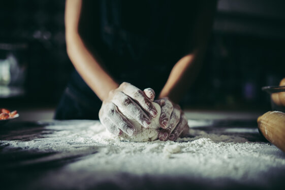 woman-kneads-dough-for-make-pizza-on-wooden-cooking-concept.jpeg