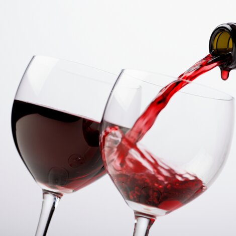 bottiglie-di-vino-di-vista-frontale-con-un-bicchiere-di-vino-sulla-superficie-scura.jpeg