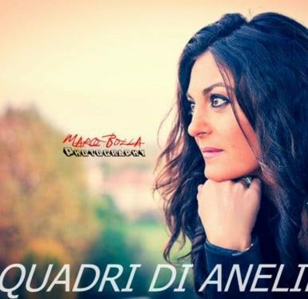 Donna che guarda assorta in uno sfondo naturale