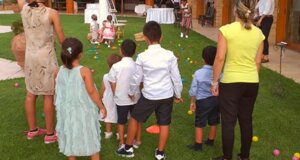 Bambini che giocano su un prato durante una festa di compleanno con animazione e giochi creativi all'aperto.