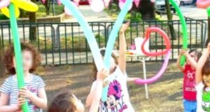 Bambini che giocano con palloncini modellabili a una festa all'aperto.