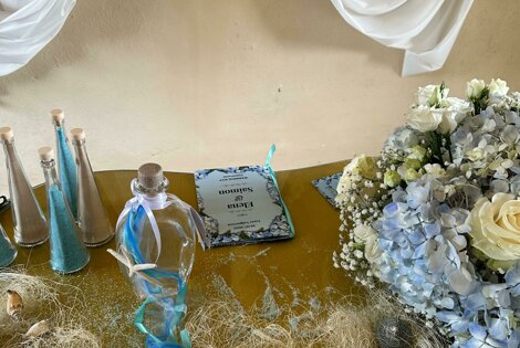 Tavolo decorato per celebrazione di matrimonio con conchiglie, rete e bouquet di fiori in Piemonte.