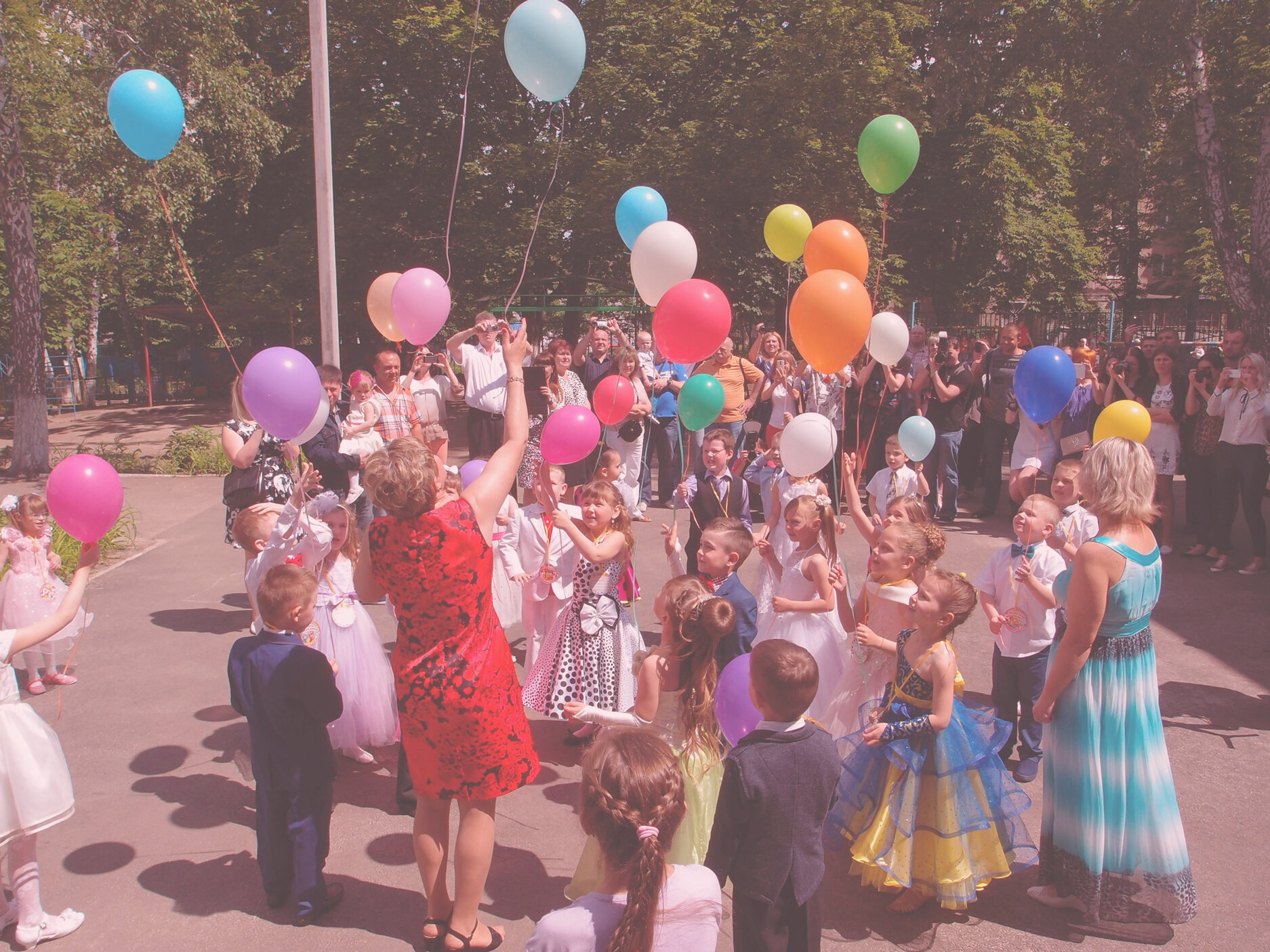 Bambini in una festa all'aperto con palloncini colorati
