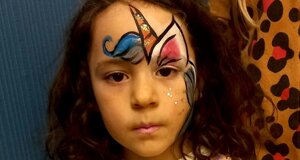 Bambina con pittura facciale colorata a tema festa