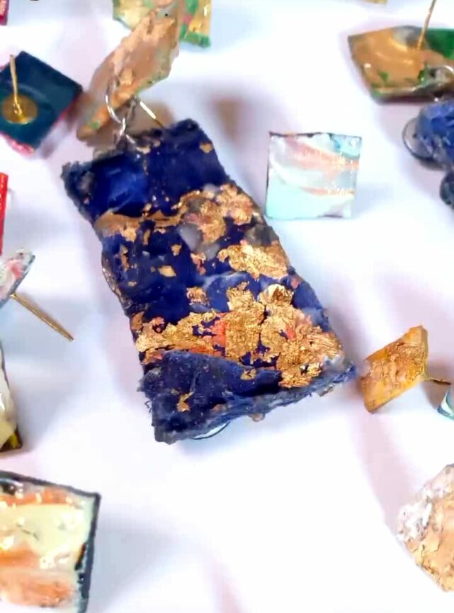 Ciondoli artigianali con dettagli dorati su sfondo bianco