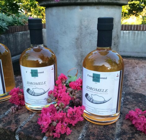 Bottiglie di idromele con fiori rosa su pietra