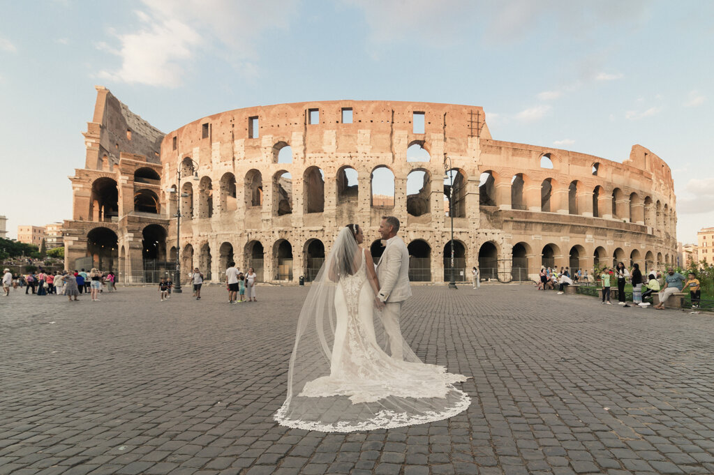 An intimate wedding in Rome and the couple poses in front of the iconic Colosseum An intimate wedding in Rome and the couple poses in front of the iconic Colosseum