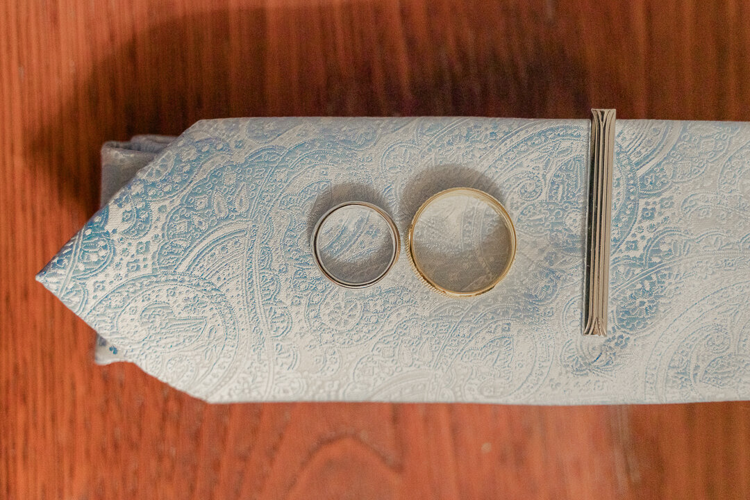umbria-wedding-photographer-locanda-rosati-orvieto---2025---03.jpeg Wedding rings on the groom's tie while the groom is getting ready for an emotional wedding in Orvieto, Umbria
