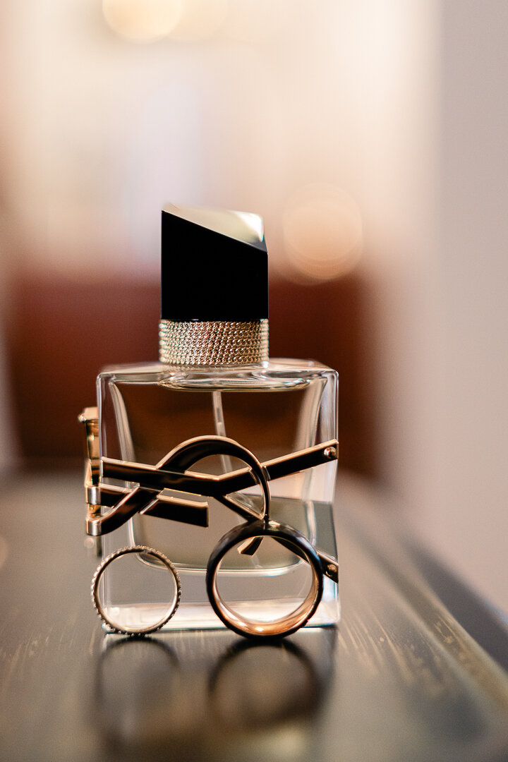 rome-wedding-photographer-les-etoiles-symbolic-wedding--2025---01.jpeg Wedding rings leaning against a luxury perfume, everything is ready for a destination wedding in Rome
