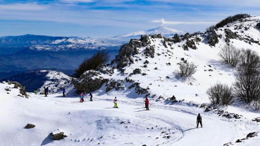 eyJpdCI6IlNjaWF0b3JpIHN1bGxlIHBpc3RlIHBhbm9yYW1pY2hlIGRlbGwnRXRuYSBTdWQgY29uIHZpc3RhIHN1bCBwYWVzYWdnaW8gaW5uZXZhdG8gZGVsbGEgU2ljaWxpYSIsImVuIjoiU2tpZXIgZGVzY2VuZGluZyBzbm93eSBzbG9wZSB3aXRoIHNwZWN0YWN1bGFyIE1vdW50IEV0bmEgc3Vuc2V0IHZpZXcgU2ljaWx5In0=