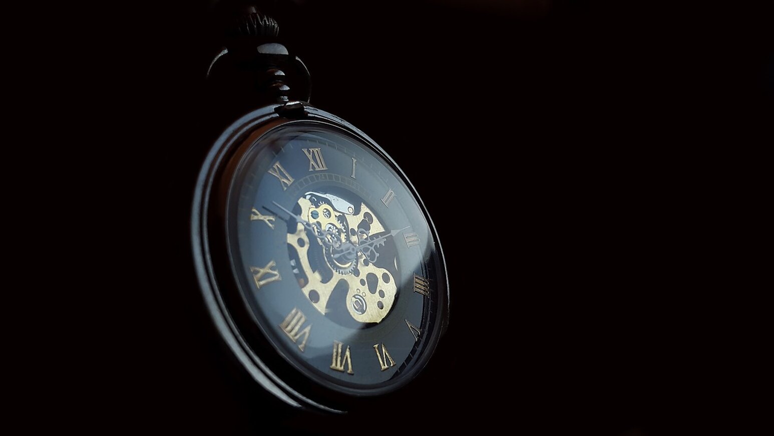 Orologio da tasca scheletrato nero con numeri romani dorati su sfondo scuro