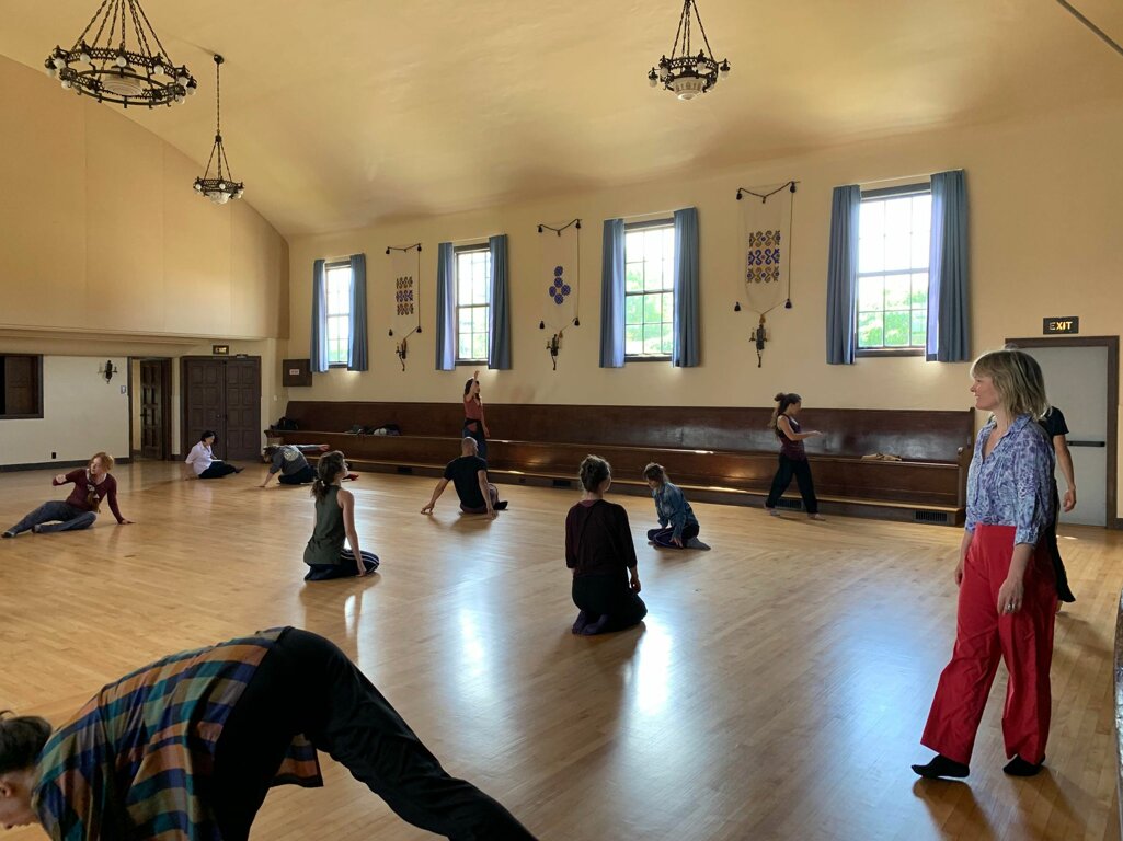 Participants exploring movement research in a spacious dance studio