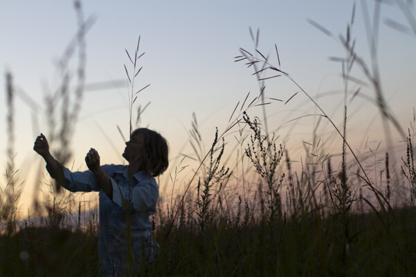 Performer exploring movement in tall grass at sunset Performer exploring movement in tall grass at sunset