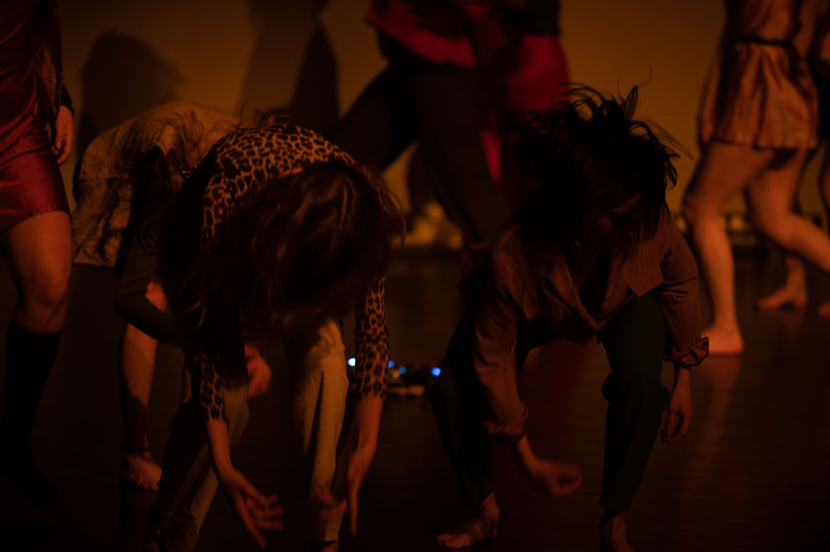 Group of dancers bending forward during a contemporary dance performance