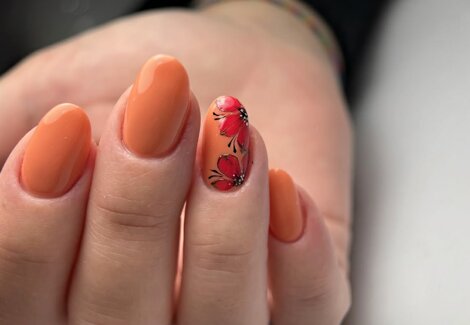 manicure dell'estetista e smalto semipermanente arancione con decorazione di papaveri rossi