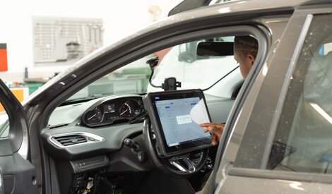 Meccanico esegue test e analisi elettronica di un veicolo in officina riparazioni auto