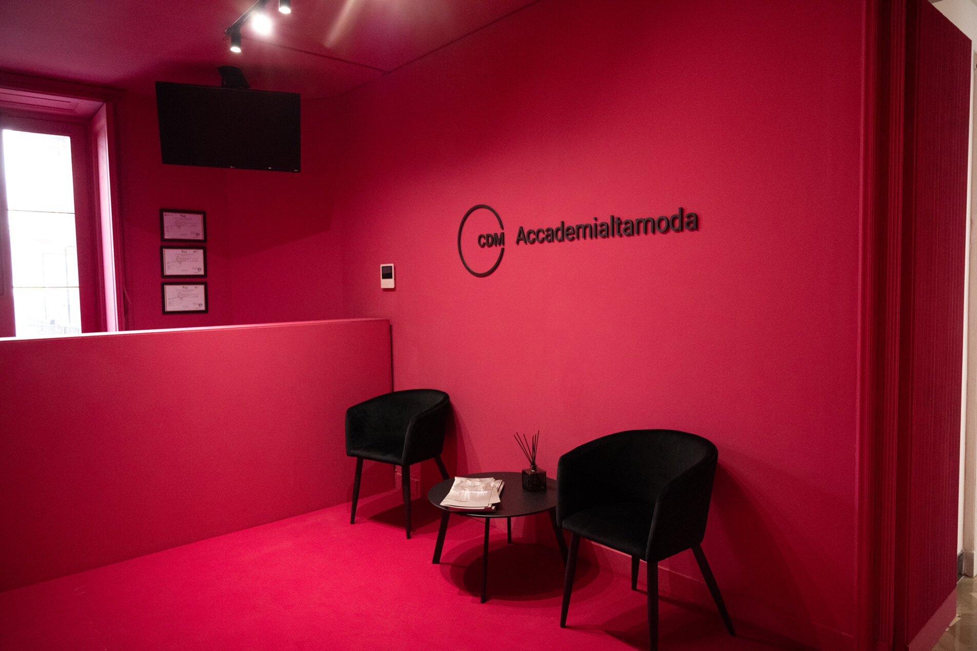 Modern red interior of a fashion academy reception with chairs and table