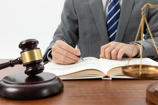 closeup-shot-person-writing-book-with-gavel-table.jpeg
