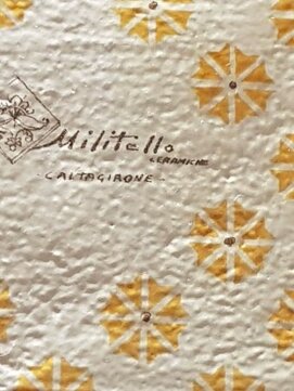 Sicilian tiles with yellow floral patterns and Militello Ceramics logo.