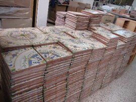Stack of Sicilian tiles in workshop showcasing handcrafted Mediterranean design.