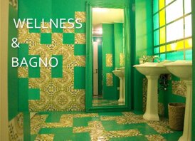 Bathroom with green and Sicilian tiled design, featuring double sinks and a large mirror.